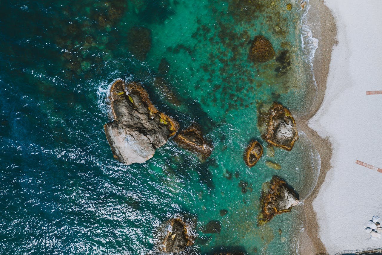 Stunning aerial shot of Berehove beach with turquoise waters and rocky shore. Perfect for travel and nature themes.